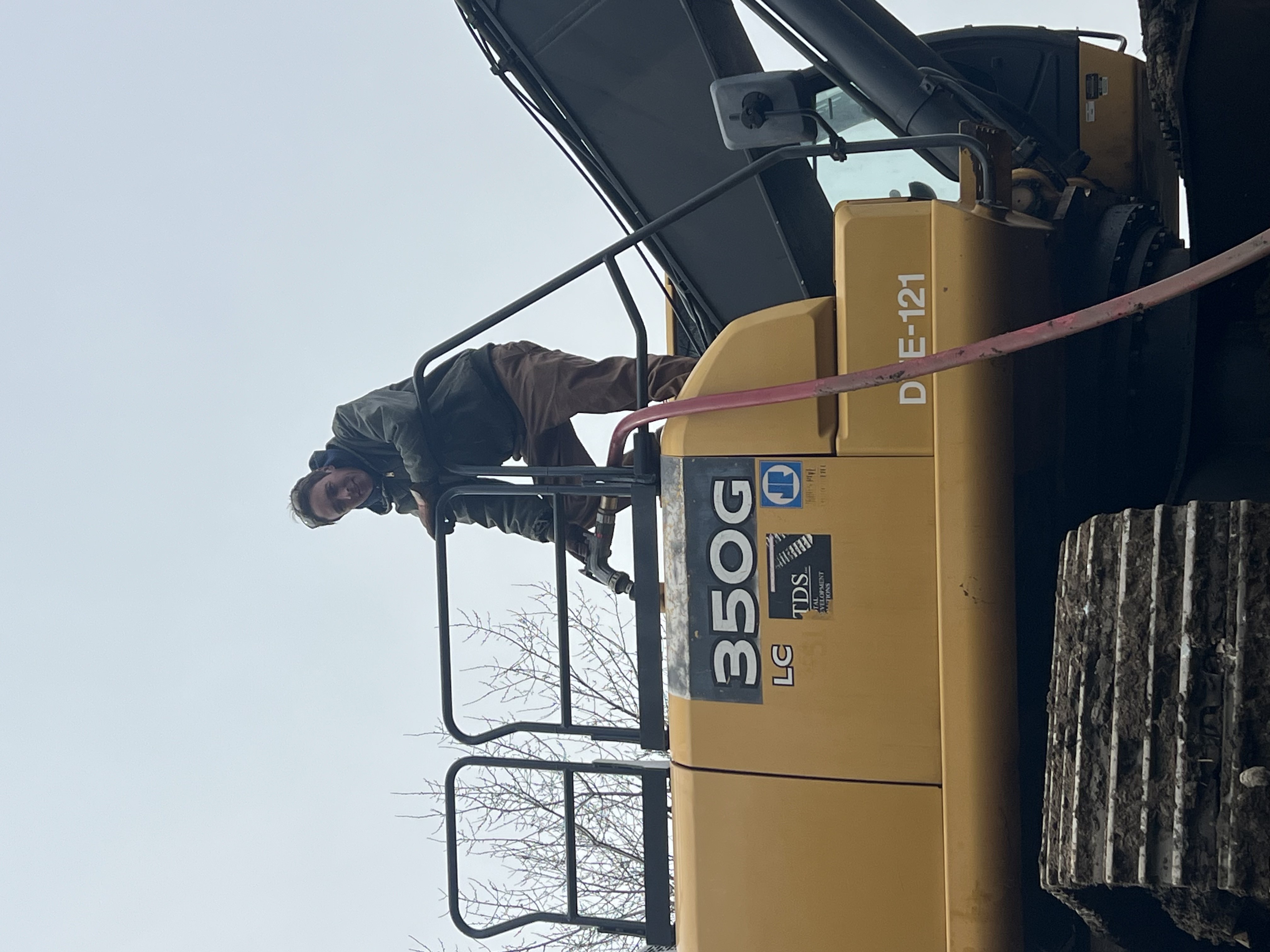 Chris on excavator — property solutions work